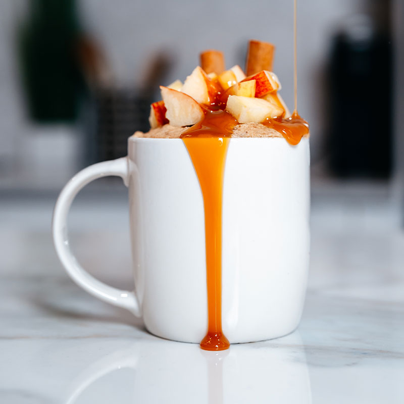 Apple spice mug cake with apple pieces and caramel drizzle