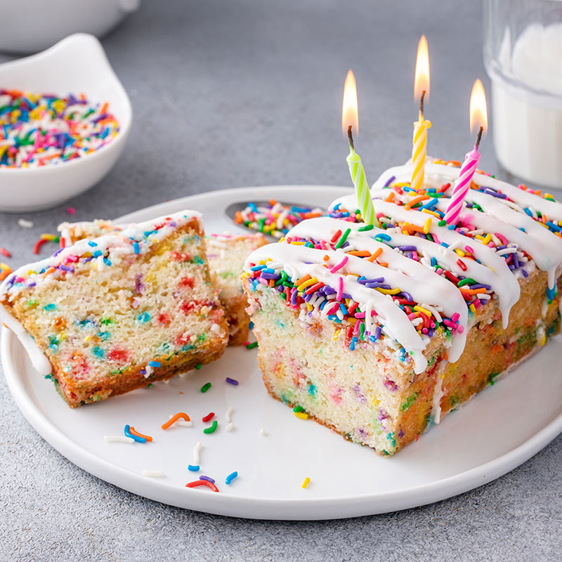 French vanilla confetti loaf with white icing, sprinkles and candles