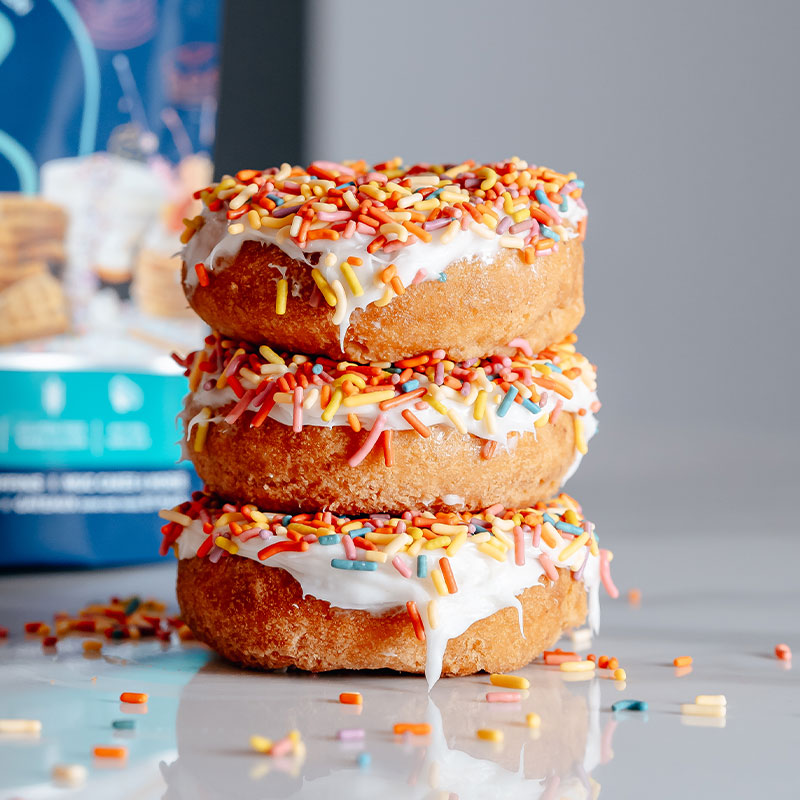 Vanilla confetti donuts with white frosting and colorful sprinkles