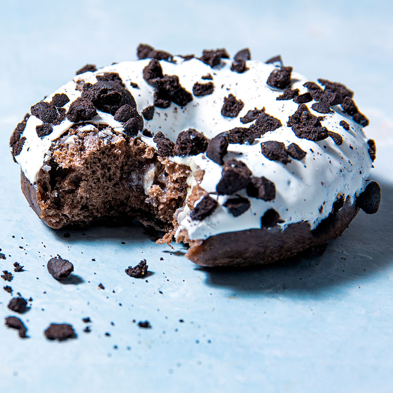 Chocolate glazed donut topped with cookie pieces